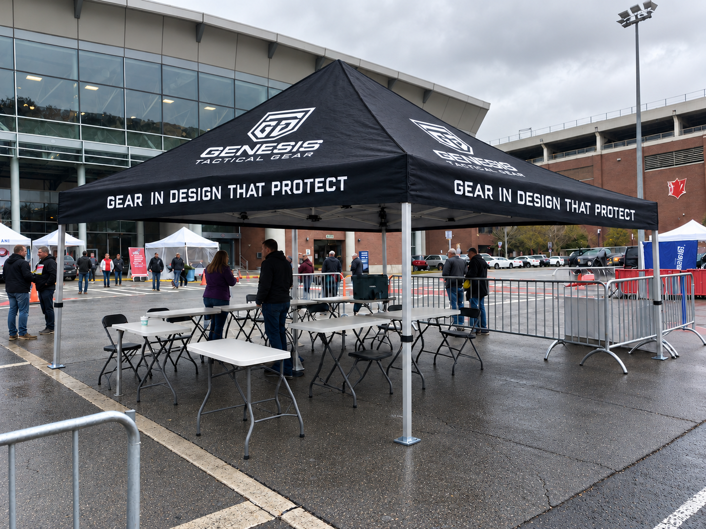 Black Genesis Tactical Gear canopy tent with tables, chairs and crowd barriers set up outside an arena entrance
