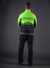 Rear-view of male model wearing a standard length, waterproof, long sleeve jacket, with upright collar and no rain-cap over tactical pants.Bottom half is black, topped by fluorescent green top, shoulders, and top of arms. Underarms, wristbands, front zipper, inner lining in collar, velcro patch on both chests and left shoulder are black. Two 2” reflective horizontal stripes cross the jacked mid and bottom. Logo patch on both chests and left shoulder.
