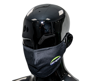 Black cotton cloth facemask worn by a mannequin. Genesis name in white is topped by a fluorescent green half-moon logo on top, on the left side of the mask.