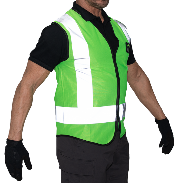 A male model wearing a fluorescent green reflective mesh vest over a black short sleeved shirt, black pants, and black gloves. A vertical 2-inch reflective silver tape comes down from the top of the shoulder and stops at the intersection of the horizontal reflective waistline.