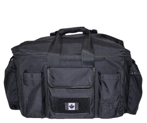 Front of field bag, displaying its middle front pocket with Canadian flag on velcro patch at the bottom, one smaller pocket on each side,  GTG embroidered on the right one, and two end pockets with closed top zipper. Featuring carry-on handle,  attached to the second handle on top of the bag with a strap.